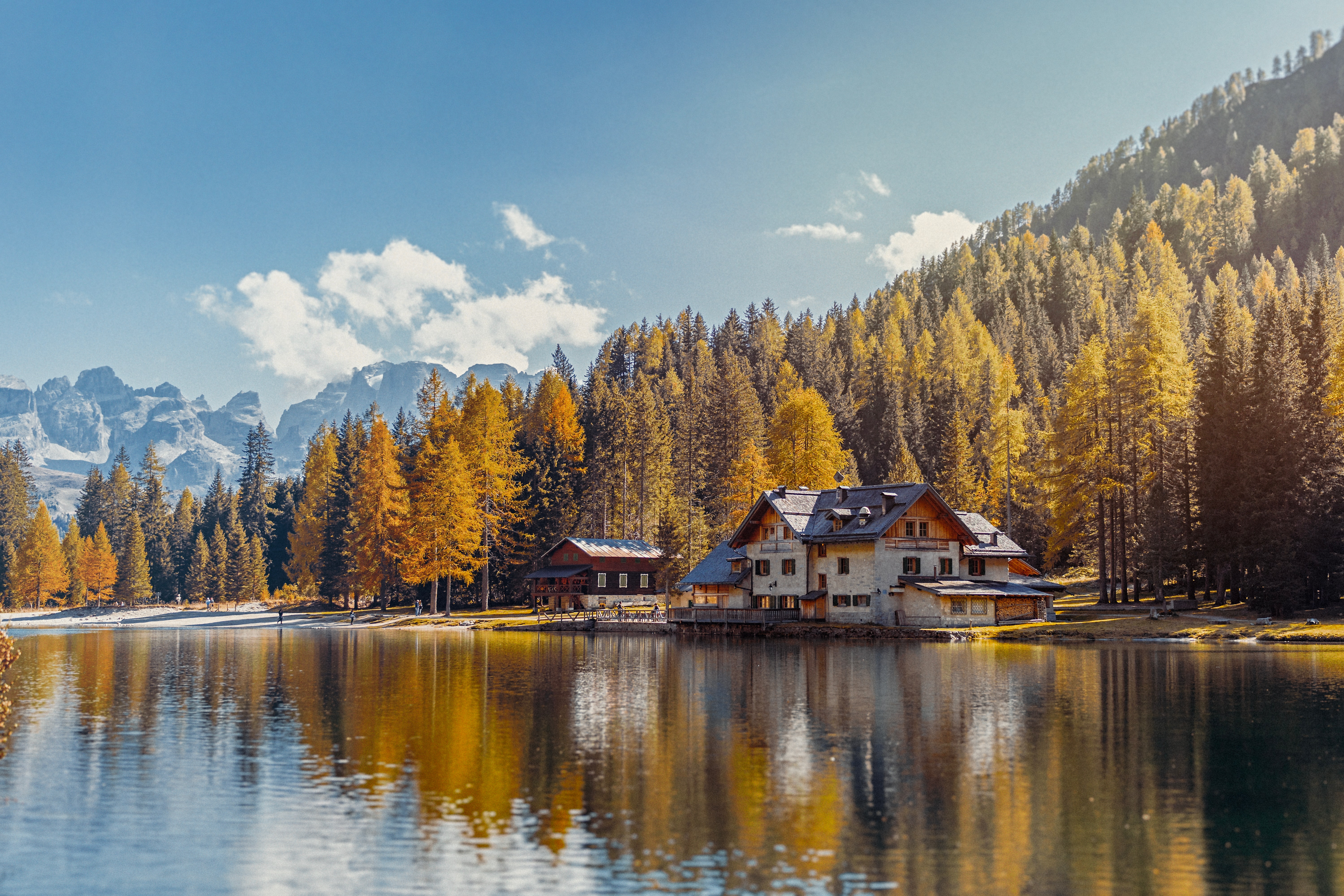 a house on a lake with mountains in the background